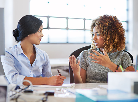 Shot of two colleagues having a discussion in an office