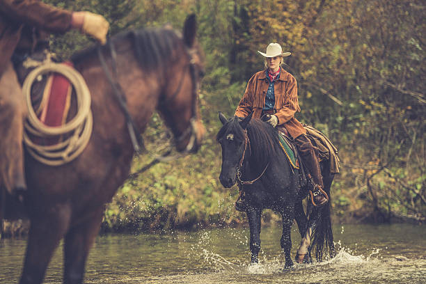 istock Cowgirl riding across a river 516899338