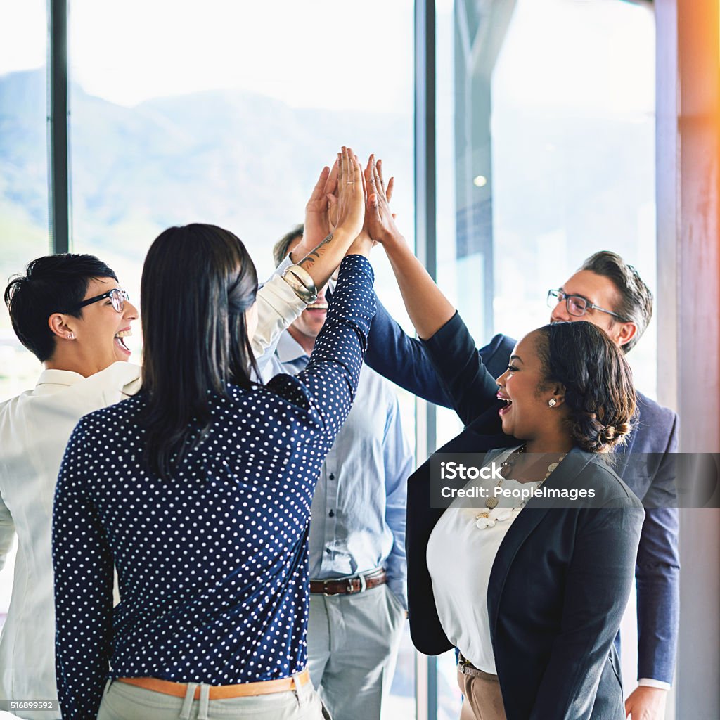 Well done team Cropped shot of a group of coworkers high-fiving in the office Business Stock Photo