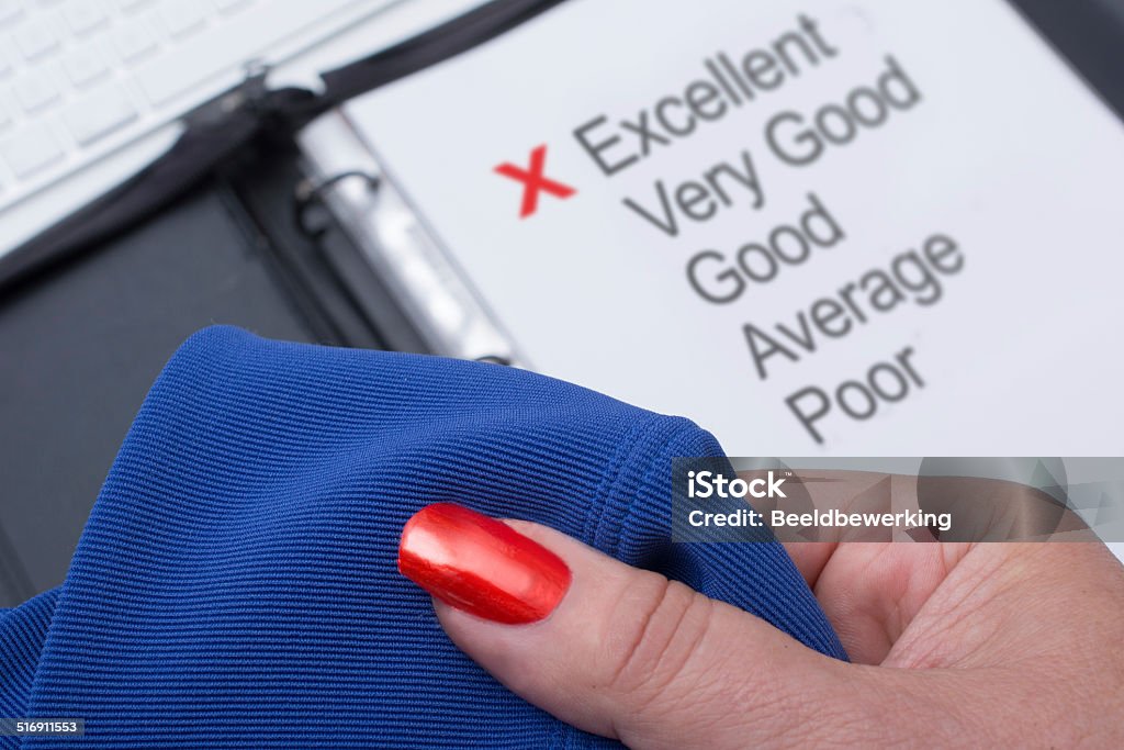 Garment Quality (English) holding a garment, with in the backdrop the word excellent highlighted Blue Stock Photo