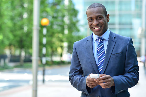 istock Smiling businessman holding smartphone 516911997