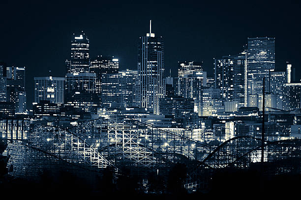 A blue tinted nighttime skyline photo of Denver, Colorado.