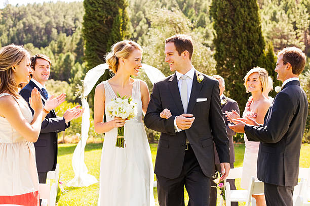 istock Couple Looking At Each Other With Guests Clapping During Wedding 516912617