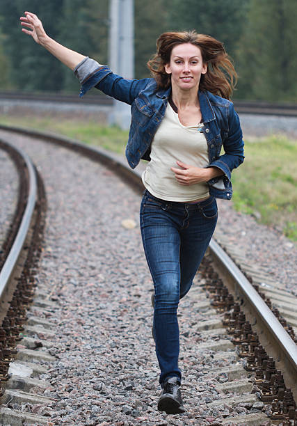 istock Young woman running railway 516913585