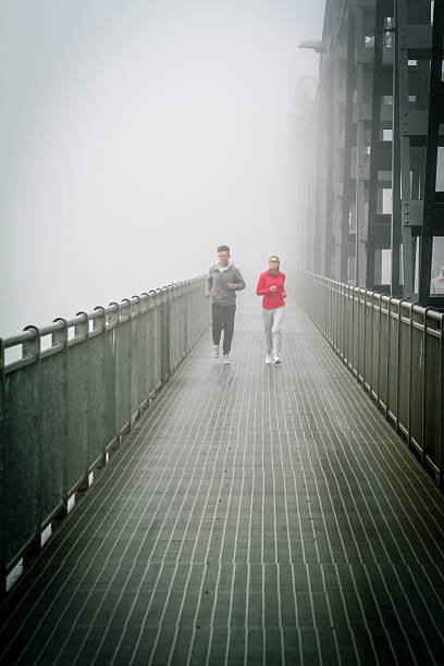 Couple Running in the fog on Iron Bridge