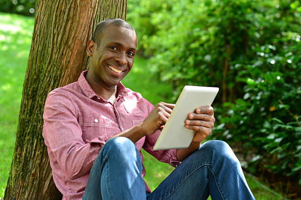 istock Handsome man with tablet in the park 516915653