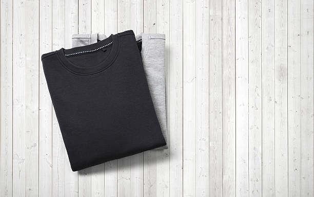 istock Two blank jumpers lying on white wood background 516916159