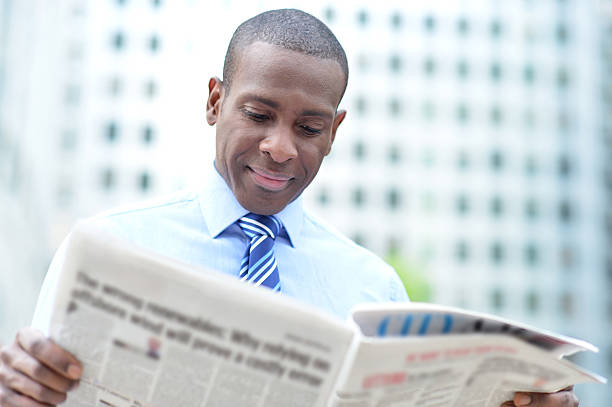 Corporate man reading news at outdoors stock photo