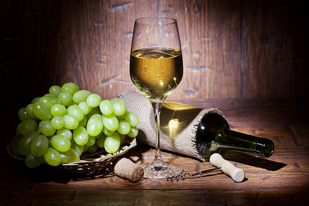 istock Wine bottles with glass on wooden background 516918908