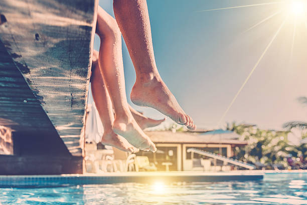 istock naked legs dangling  over blue swimming pool 516920768