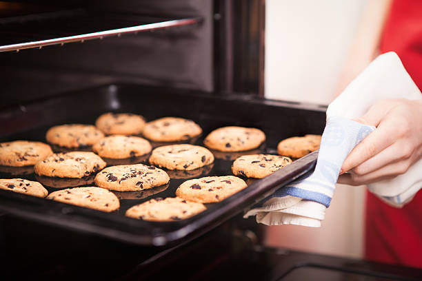 chocolate chip cookies chocolate chip cookies on baking pan hot out of the oven close up baking sheet stock pictures, royalty-free photos & images