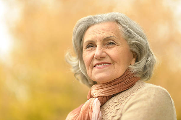 istock senior woman in  autumn park 516923060