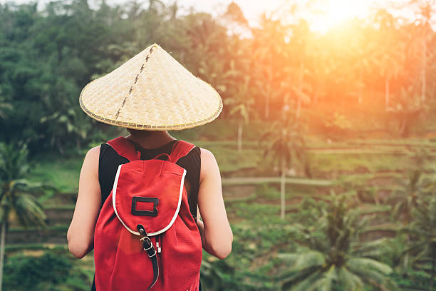istock Young lady with traditional Asian hat and backpack 516925502