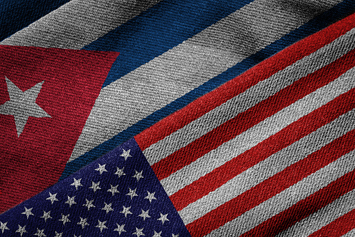 3D rendering of the flags of USA and Cuba on woven fabric texture. Detailed textile pattern and grunge theme.