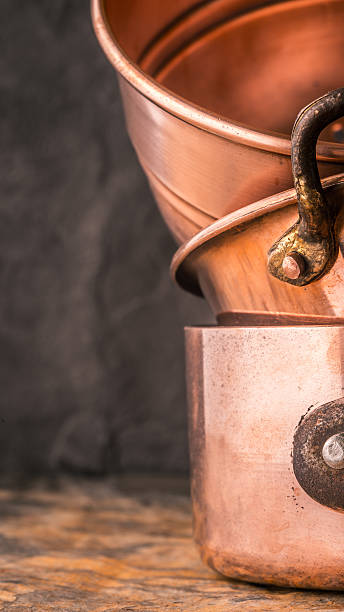 istock Copper pots and pans on the stone table 516928406