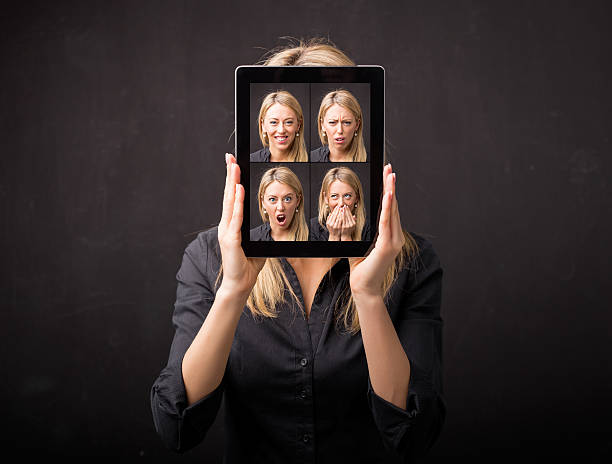 istock Woman holding tablet with different faces in front of her 516929880