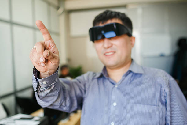 Man in a virtual reality helmet points finger up stock photo