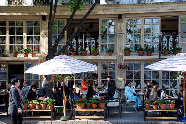 Odessa, Ukraine - April 29, 2010: People sitting in beautiful outdoor cafe on the main street Deribasovskaya in Odessa, Ukraine .