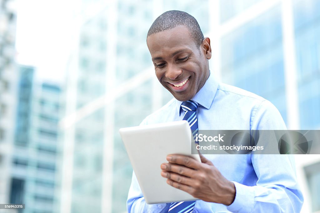 Business professional using a tablet pc Businessman in formals using tablet device Men Stock Photo
