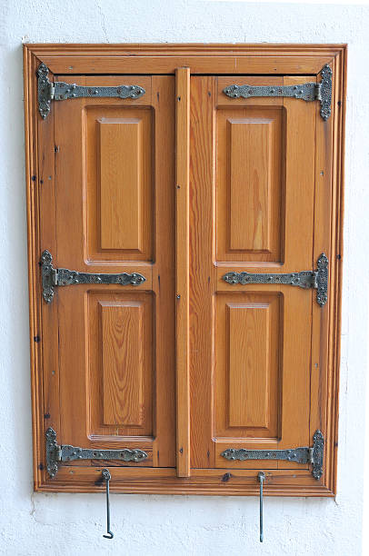 istock Closed wooden shutters on a white wall 516944131