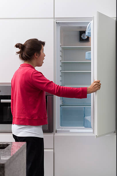 istock Terrified woman against the empty fridge 516946861