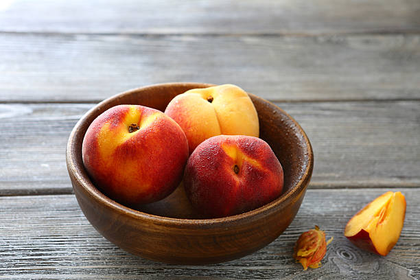 istock three sweet peaches in a bowl 516947541