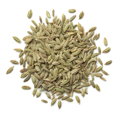 Heap of green fennel seeds on white background