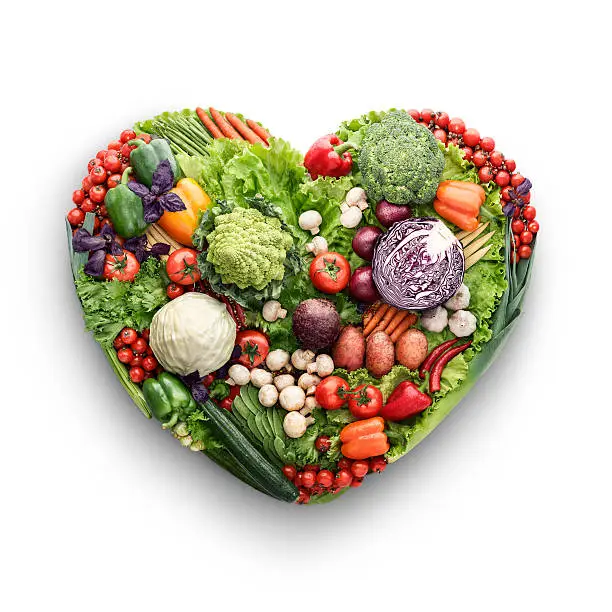 Healthy food concept of a human heart made of vegetable and fruit mix that reduce death risk, isolated on white.