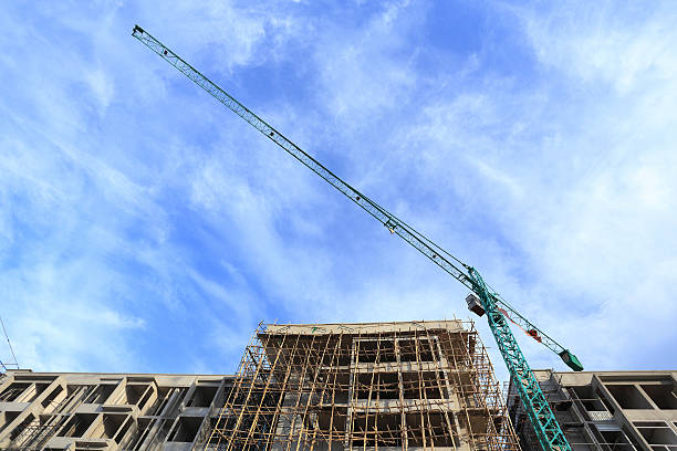 local de construção com guindastes no céu azul de fundo - tower steel mansion investment imagens e fotografias de stock