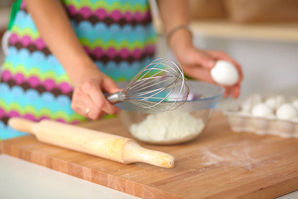 istock Smiling young woman in the kitchen, isolated on background 516949273