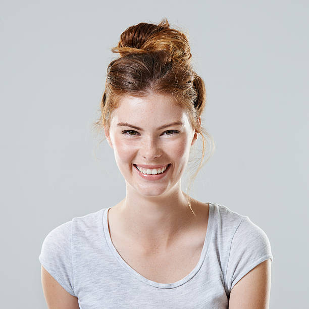 Radiantly beautiful Cropped studio portrait of a beautiful young woman against a gray background hair bun stock pictures, royalty-free photos & images