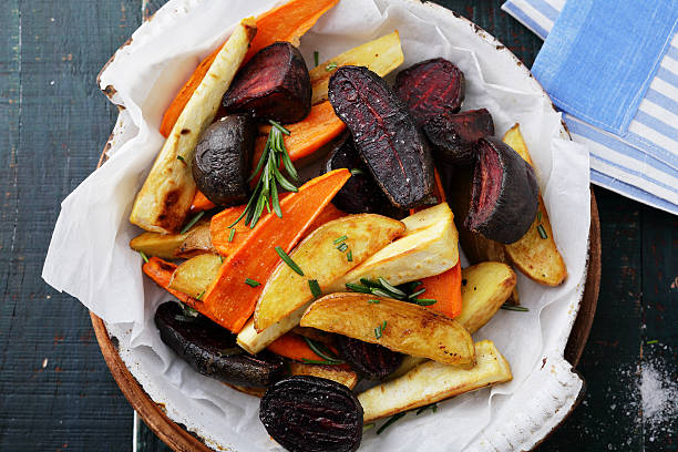 baked carrots and beets with herbs stock photo