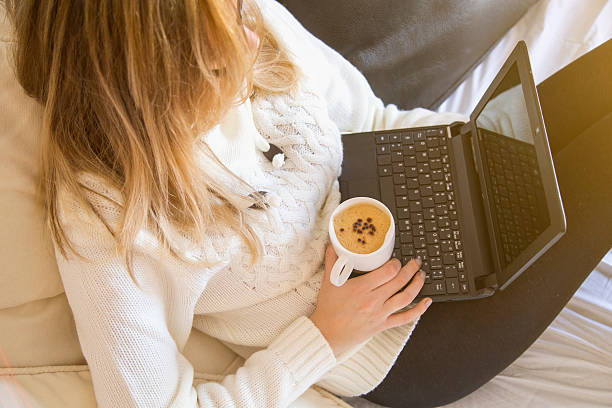 femme avec un ordinateur portable et tasse de café - knitting residential structure glasses hot drink photos et images de collection