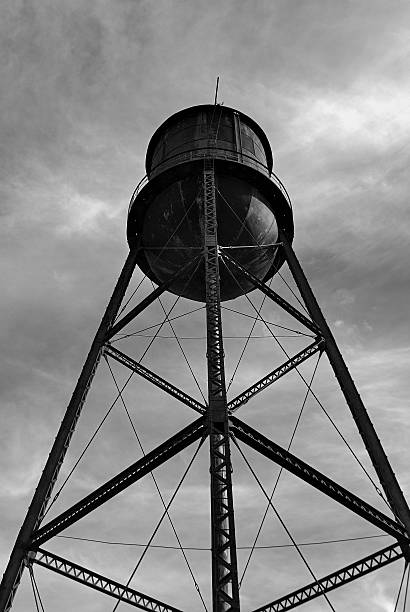 istock Old obsolete water tower stands against the sky 516955090