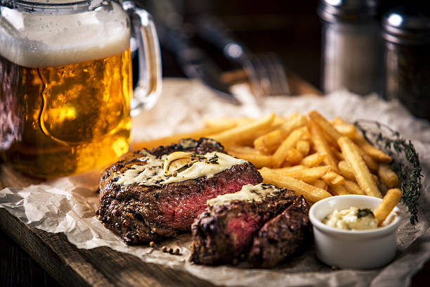 Healthy lean grilled medium-rare steak with french fries, beer