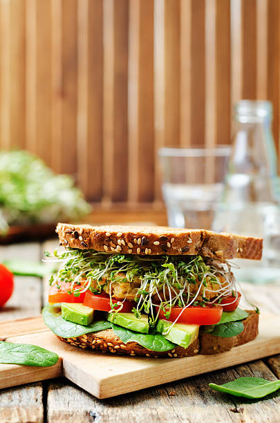 istock sprouts avocado tomato spinach chickpeas burger rye sandwich 516957556