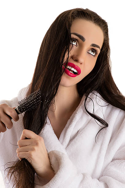 istock beautiful woman combing hair with sad face 516958098
