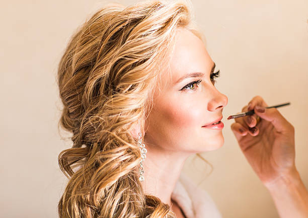 istock Wedding makeup artist making a make up for bride. Beautiful 516958976