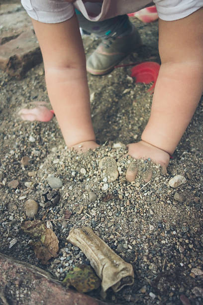 istock Baby girl playing in sand 516977580