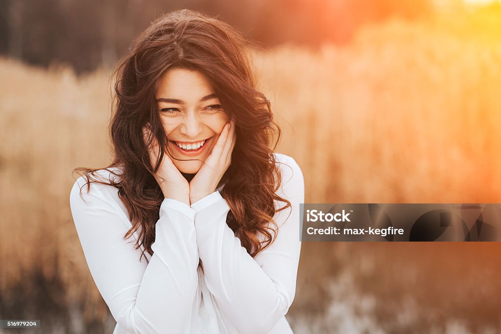 Face laughing woman outdoors beautiful sunny portrait of a girl wearing white clothes. Face laughing woman outdoors with copy space Women Stock Photo