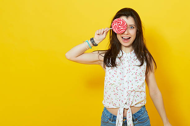 istock happy woman holding a lollipop. 516980338