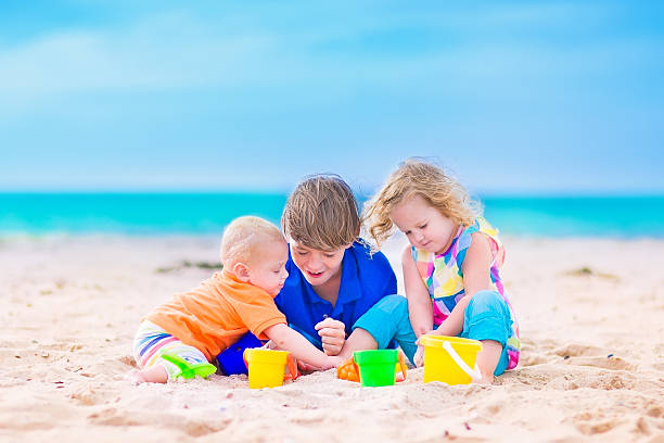 istock Three kids on a beach with toys 516980699