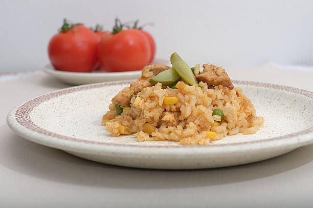 Homemade risotto with corn, peas and chicken on a plate on the table
