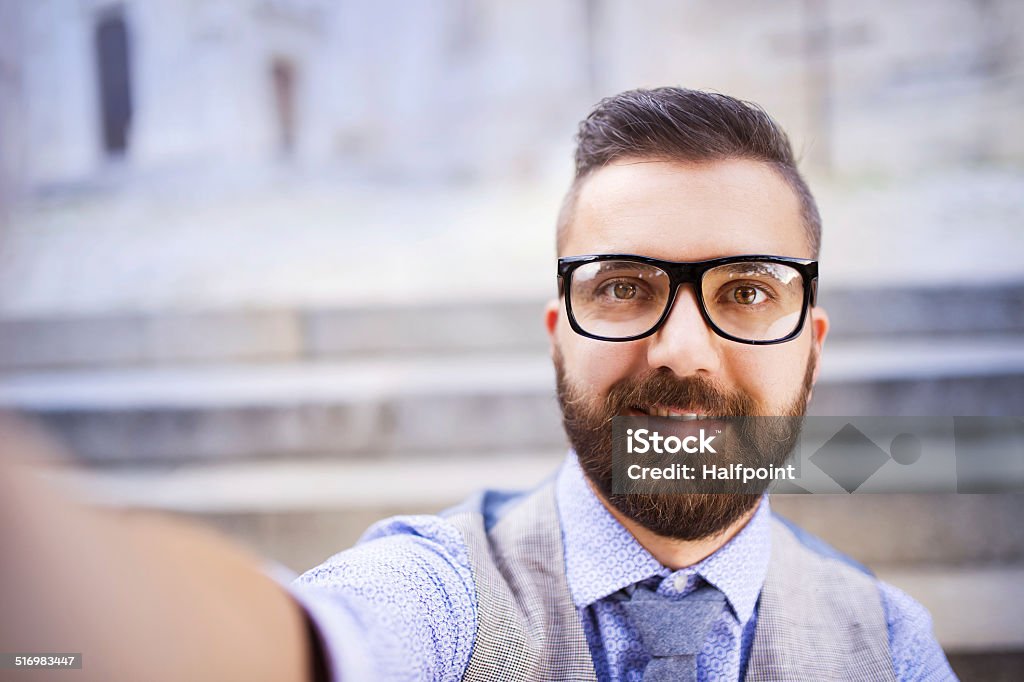 Hipster businessman taking selfie Young urban businessman taking selfie in city street Button Down Shirt Stock Photo