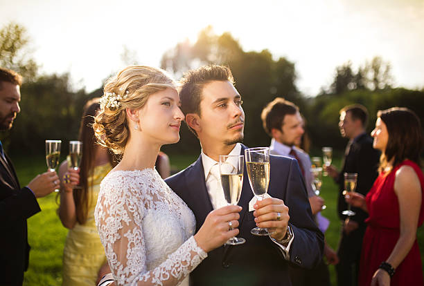 istock Newlyweds clinking glasses outside 516984537