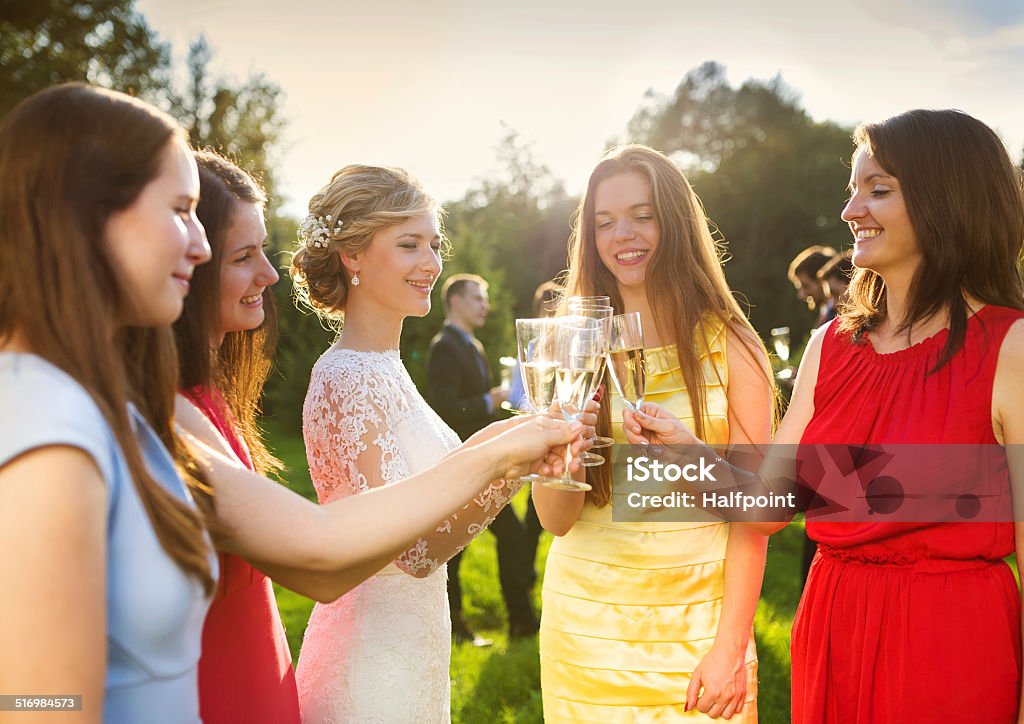 Bride with bridesmaids toasting Bride with four happy bridesmaids toasting at the wedding reception outside Wedding Guest Stock Photo