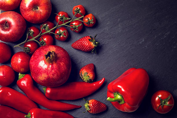 Red healthy vegetables and fruits on a black slates
