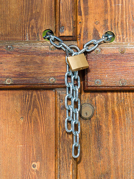 istock Lock  and shiny chain closing a wooden garden gate 516985464