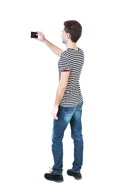 istock Back view of man with tablet. Standing young guy. 516985636