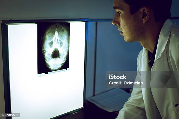 Young Doctor Looking At Xray Stock Photo - Download Image Now - Doctor, Paranasal Sinus, X-ray Image